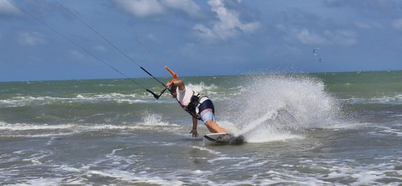 "Des kitesurfeurs en progression sur une plage au Brésil, encadrés par l'école B&Bob Kiteboarding."
